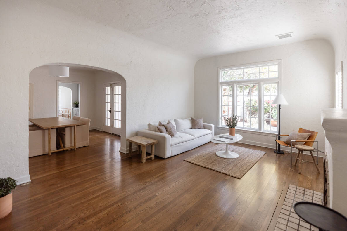 Staged bedroom with natural light and neutral bedding prepared for real estate photography