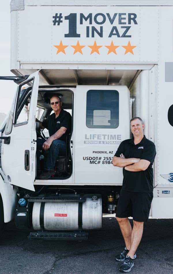 Lifetime Moving & Storage mover standing beside a branded moving van
