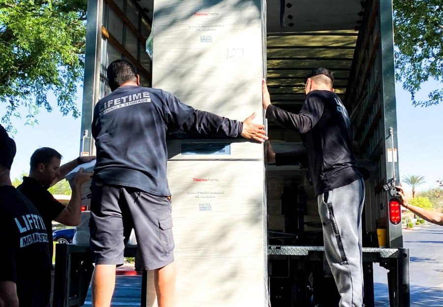 Lifetime Moving & Storage white glove delivery specialist carefully transporting a wrapped item